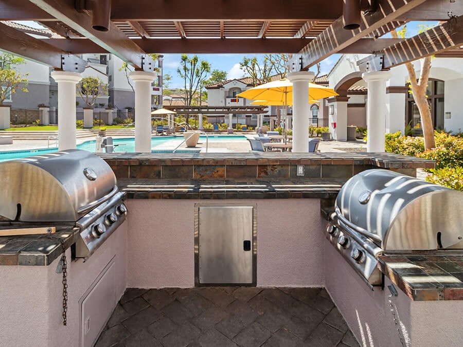 Outdoor BBQ Area with Canopy & View of Pool at Reserve at Rancho Apartments located in Moreno Valley, CA.