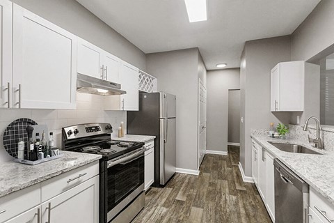 a kitchen with white cabinets and stainless steel appliances