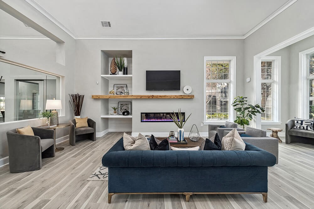 Community Clubhouse with Lounge Furniture and Fireplace at Bridges at Oakbend Apartments in Lewisville, TX.