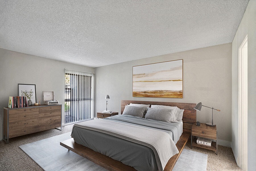 Model Bedroom with Carpet and Patio Accessibility at Madison Park Apartments located in Anaheim, CA.