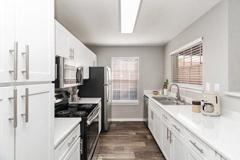 a kitchen with white cabinets and a black stove