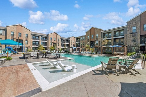 Community Swimming Pool with Pool Furniture at Alta 3Eighty Apartments located in Aubrey, TX.