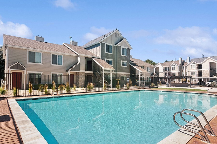 Community Swimming Pool with Pool Furniture at Broadmoor Village Apartments located in West Jordan, UT.