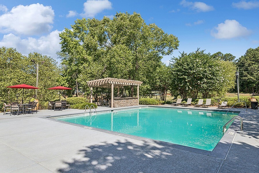 Community Swimming Pool with Pool Furniture at Lakeside Retreat Apartments located in Peachtree Corners, GA.
