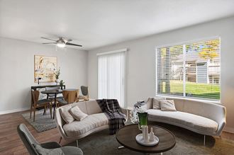Model Living Room with Wood-Style Flooring and Patio Accessibility at Overlook Point Apartments in Salt Lake City, UT.