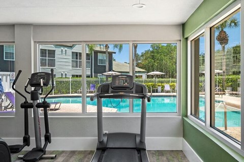 Community Fitness Center with Equipment and Pool View at Waverley Place Apartments in Naples, FL.