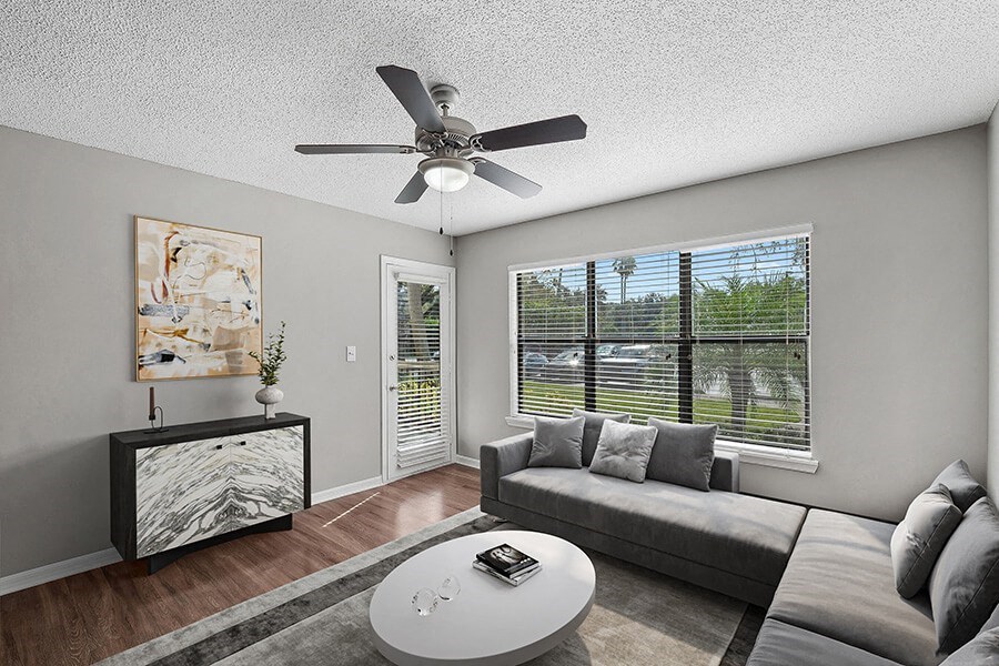 Model Living Room with Wood-Style Flooring and Patio Accessibility at Fountains Lee Vista Apartments in Orlando, FL.