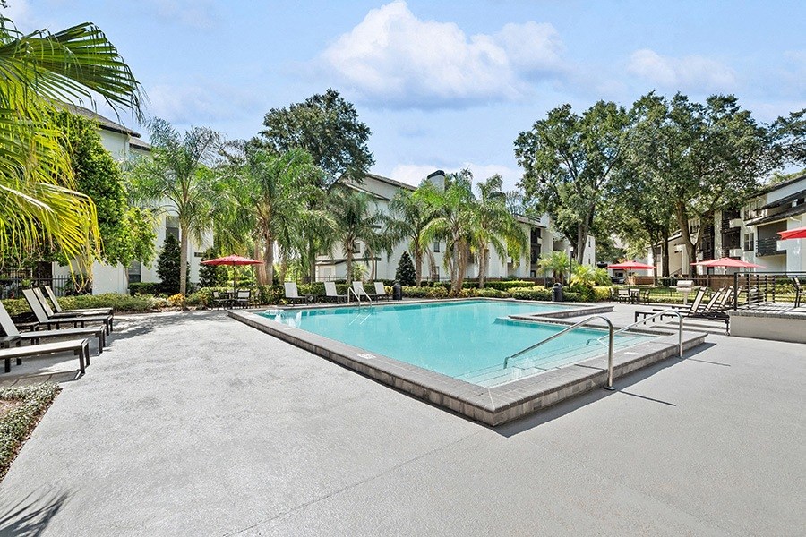 Community Swimming Pool with Pool Furniture at Rosehill Preserve Apartments in Orlando, FL.