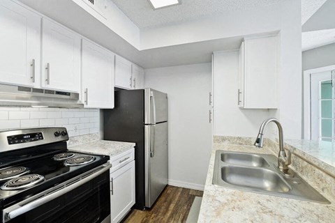 a kitchen with a stove refrigerator and sink