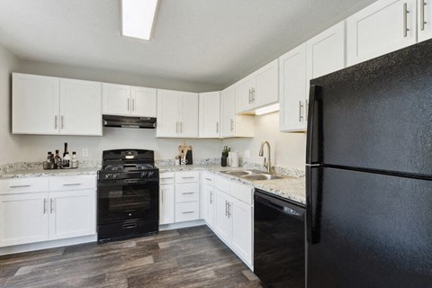 a kitchen with black appliances and white cabinets