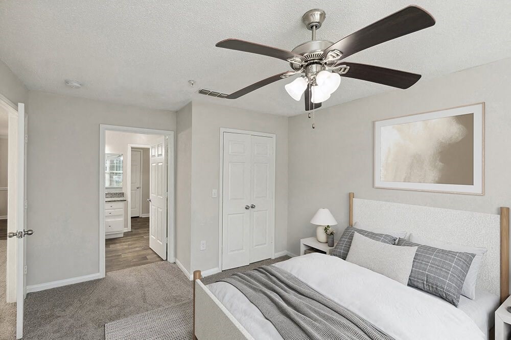 Model Bedroom with Carpet and attached Bathroom at Shadow Ridge Apartments in Riverdale, GA.