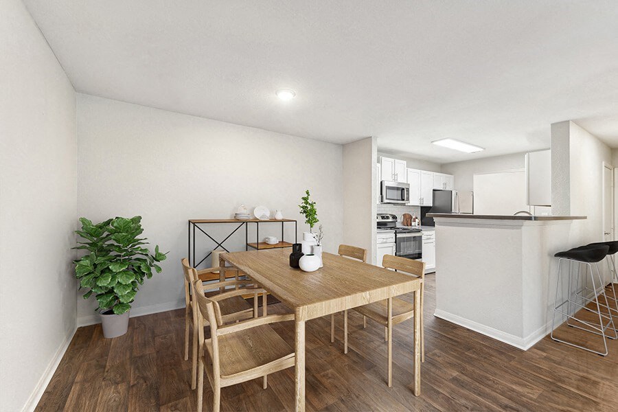 Model Dining Room with Wood-Style Flooring and View of Kitchen at Lake Cameron Apartments located in Apex, NC.