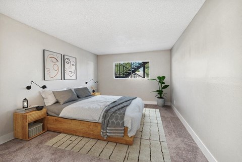 Mesa, AZ, Apartments Near Light Rail - The District at Fiesta Park - Cozy Bedroom With Wood Platform Bed, Neutral Carpet, Modern Wall Art, Nightstands, And Window Overlooking Courtyard.