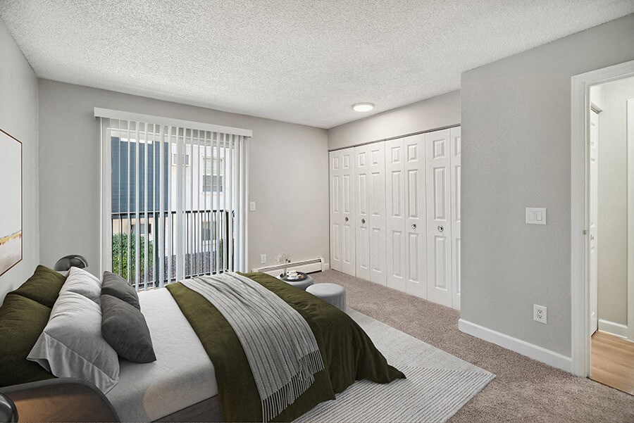 Model Bedroom with Carpet and Patio Accessibility at Waterfront Apartments in Lakewood, CO.