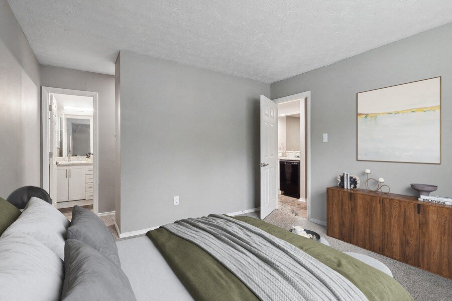 a bedroom with a bed and a dresser and a bathroom