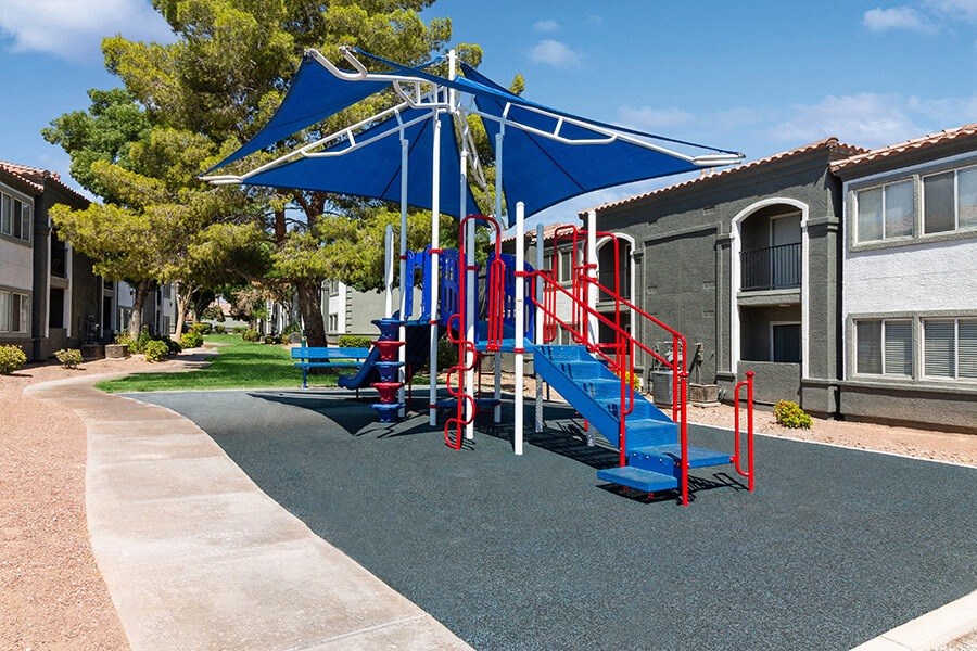 Community Playground with a Slide and Blue Canopy at Loma Vista Apartments in Las Vegas, NV.