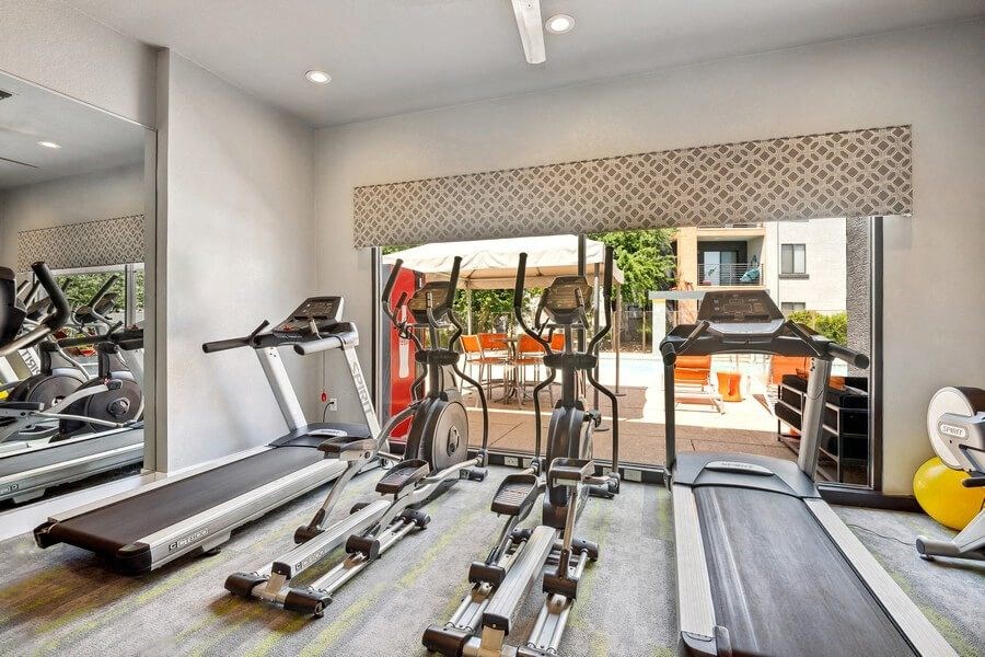 Community Fitness Center with Equipment and Mirrors at Harmony at Surprise Apartments in Surprise, AZ.