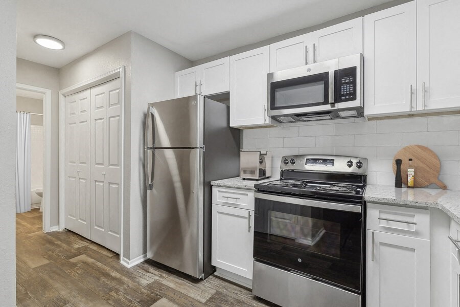 a kitchen with stainless steel appliances and white cabinets