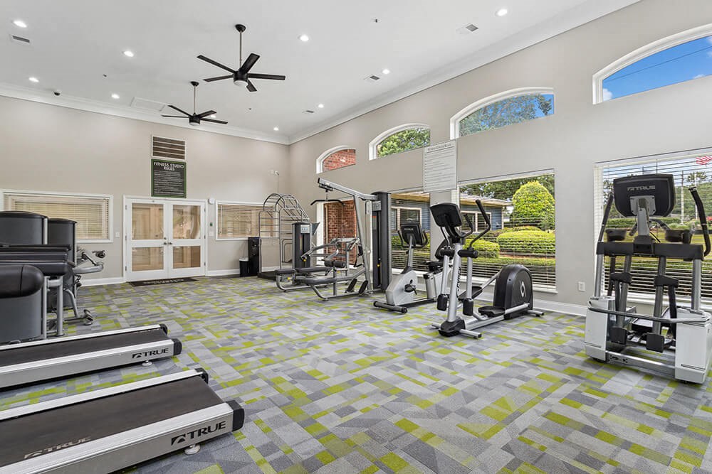 a workout room with treadmills and other exercise equipment