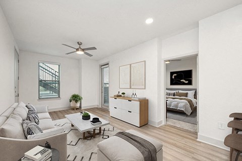 Model Living Room with Wood-Style Flooring and Patio Accessibility at Alta 3Eighty Apartments located in Aubrey, TX.