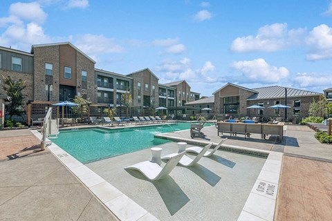 Community Swimming Pool with Pool Furniture at Alta 3Eighty Apartments located in Aubrey, TX.