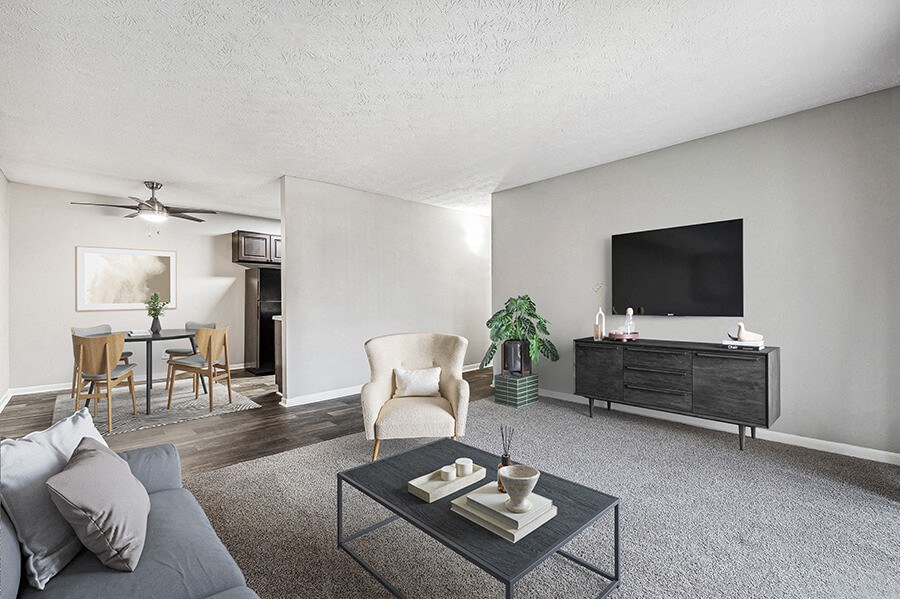 Model Living Room with Carpet and View of Dining Room at Paramont Apartments in Duluth, GA.