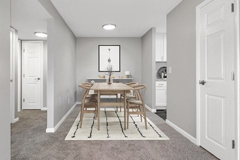 Model Dining Room with Carpet and View of Kitchen at Stone Ends Apartments in Stoughton, MA.