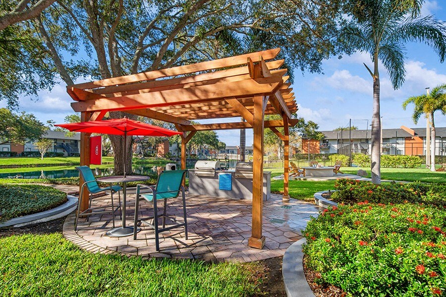Outdoor BBQ Area with Furniture and Canopy at Bridges at Bayside Apartments in St. Petersburg, FL.