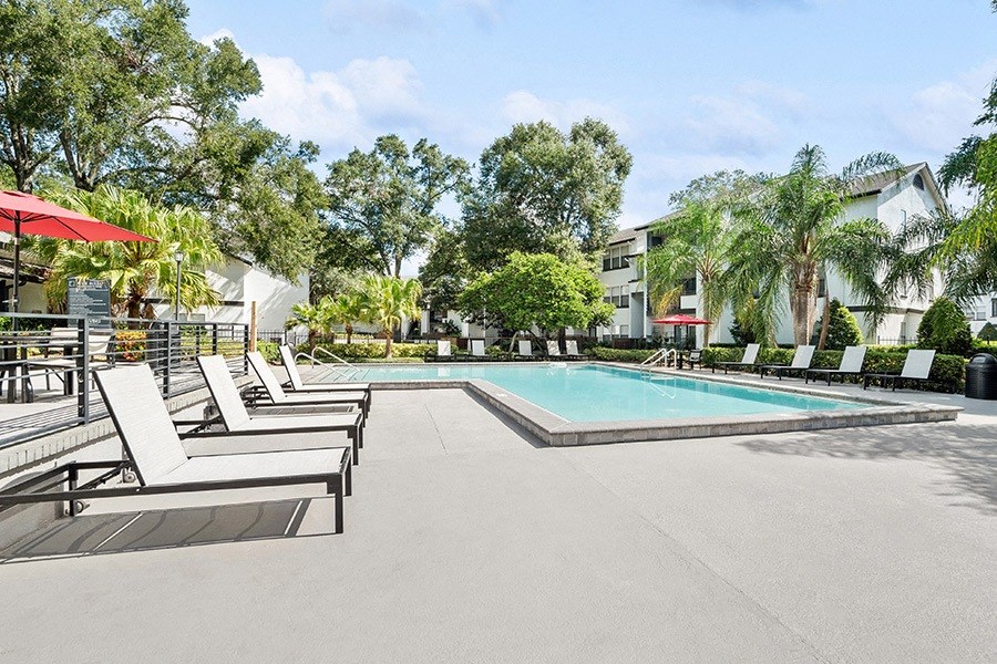 Community Swimming Pool with Pool Furniture at Rosehill Preserve Apartments in Orlando, FL.