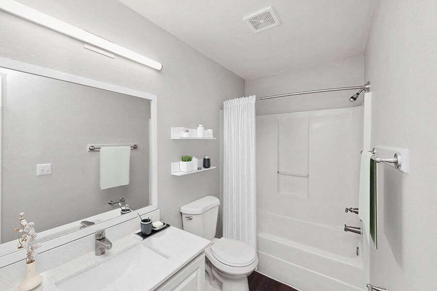 Model Bathroom with White Cabinets, Wood-Style Flooring and Shower/Tub at Vue at Baymeadows Apartments in Jacksonville, FL.