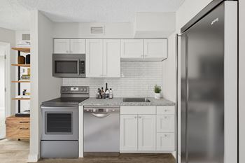 a kitchen with white cabinets and stainless steel appliances