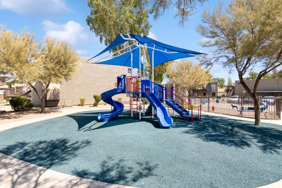 a playground with a blue and red slide at the villas at falling waters townhomes at Villages at Metro Center, Phoenix, Arizona