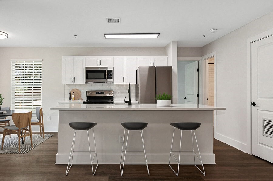 Model Kitchen with White Cabinets and Wood-Style Flooring at Park at Caterina Apartments located in Charlotte, NC.
