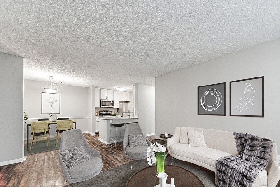 Model Living Room with Wood-Style Flooring and View of Kitchen/Dining Area at Commons at Haynes Farm Apartments in Shrewsbury, MA.