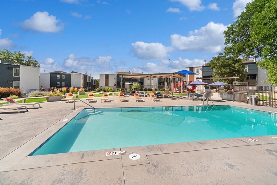 Community Swimming Pool with Pool Furniture at Waterfront Apartments in Lakewood, CO.