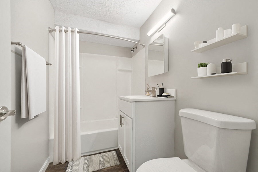 Model Bathroom with White Cabinets, Wood-Style Flooring and Shower/Tub at Meadows at Marlborough Apartments located in Marlborough, MA.