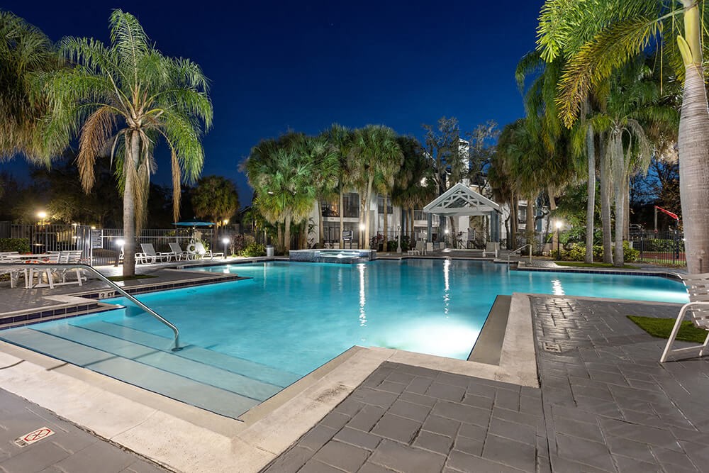 Community Swimming Pool with Pool Furniture at Caribbean Breeze Apartments in Tampa, FL.