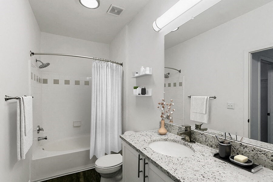 Model Bathroom with White Cabinets, Wood-Style Flooring and Shower/Tub at Parkside at Town Center Apartments in Marietta, GA.