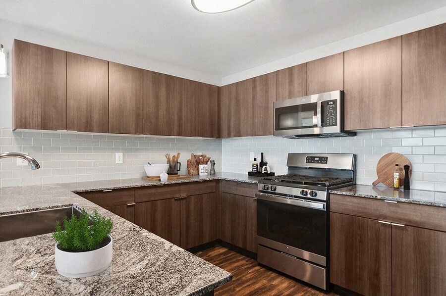 Model Kitchen with Wood-Style Flooring & Dark Oak Cabinets at Seven Skies Apartments located in Sandy, UT.