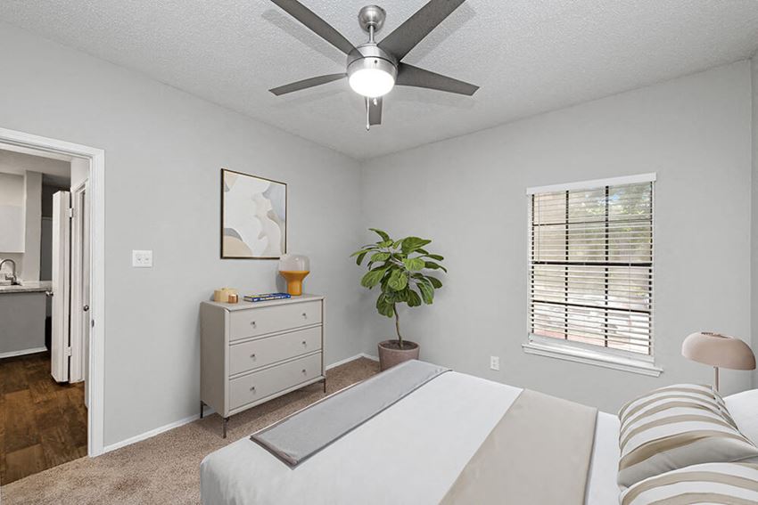 Model Bedroom with Carpet and Window View at Heatherstone Apartments in Dallas, TX.