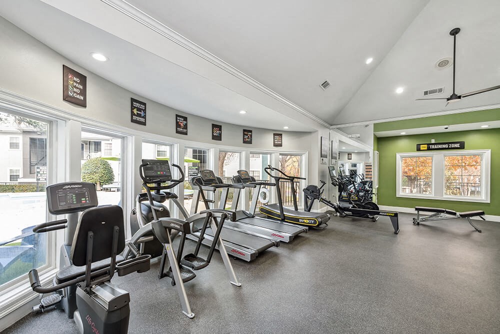 Community Fitness Center with Equipment at Bridges at Oakbend Apartments in Lewisville, TX.