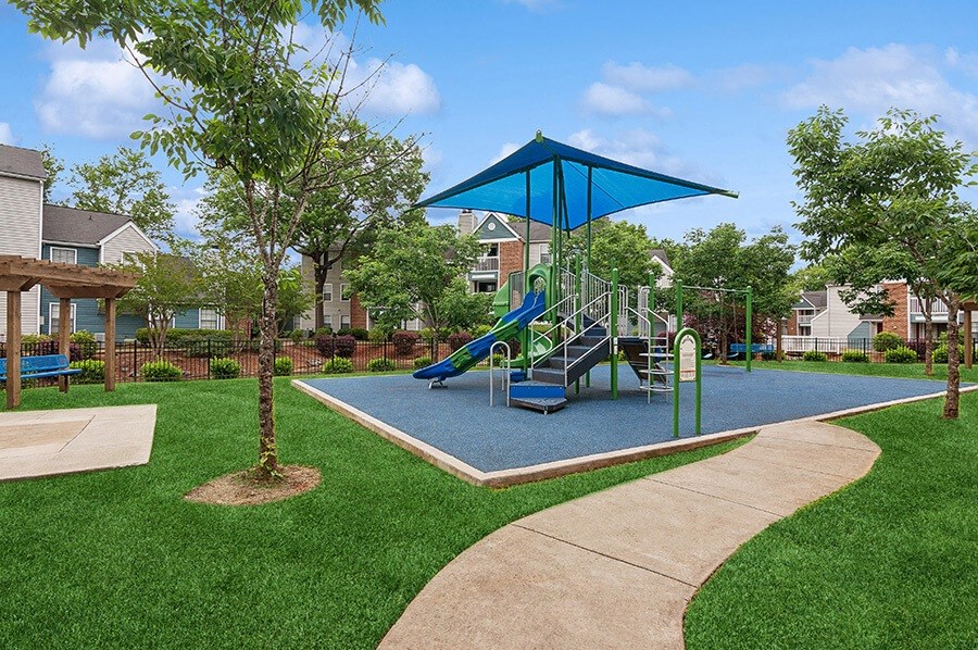 Community Playground with a Slide, Blue Canopy and Swing Set at Park 2300 Apartments in Charlotte, NC.