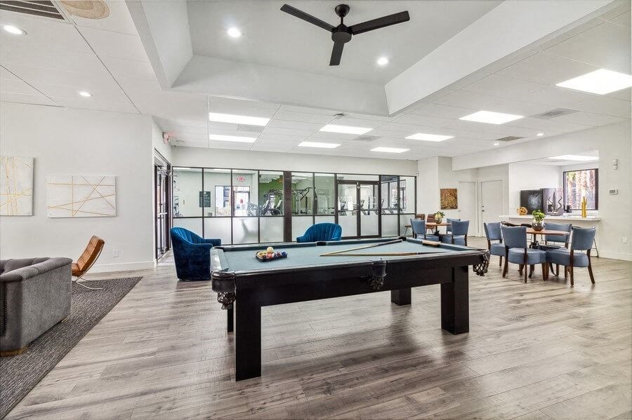 a pool table in a room with a couch and chairs