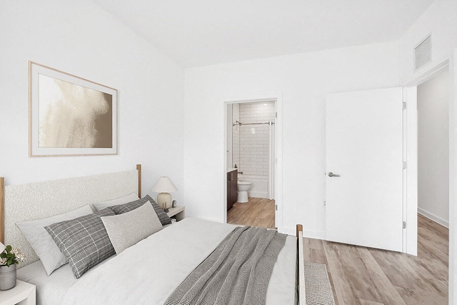 Model Bedroom with Wood-Style Flooring and attached Bathroom at Stella Apartments located in New Carrollton, MD.