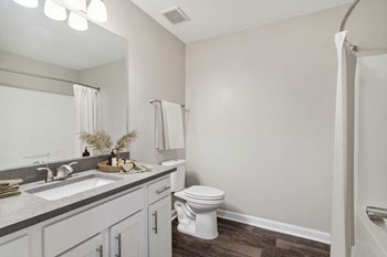 Model bedroom with white vanity at Retreat at Stonecrest Apartments - Photo Gallery 13