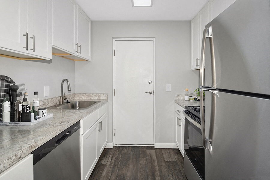 Model Kitchen with White Cabinets and Wood-Style Flooring at Stone Ends Apartments in Stoughton, MA.