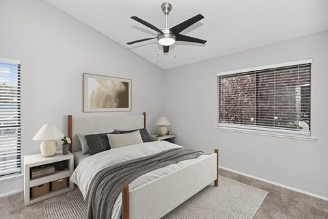 Two-Bedroom Apartments in Vallejo, CA - The Meritage - A Bedroom With Upholstered Bed, Ceiling Fan, Matching Nightstands, Soft Carpet, And Large Windows With Blinds.