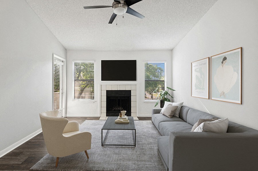 Model Living Room with Wood-Style Flooring, Fireplace & Patio Accessibility at Rosehill Preserve Apartments located in Orlando, FL.