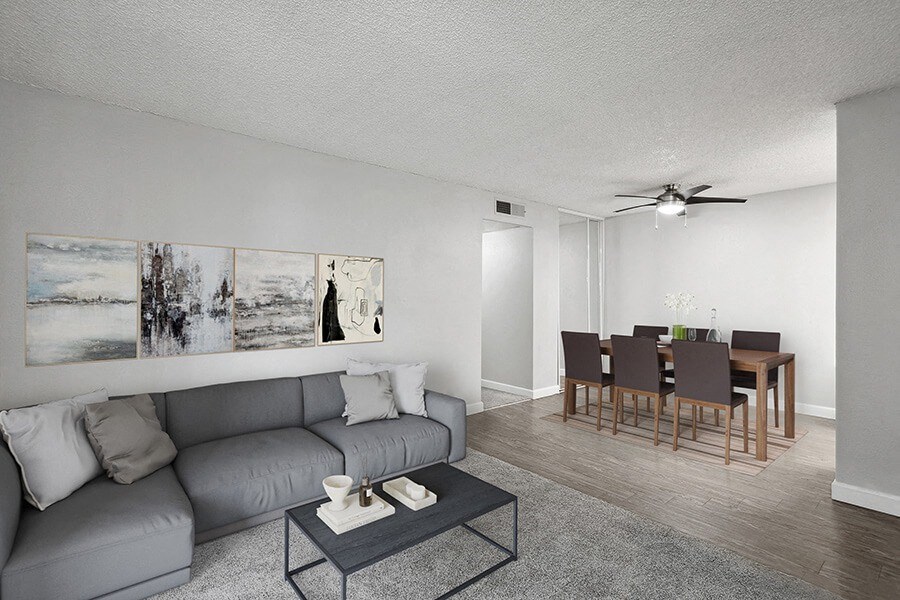 Model Living Room with Carpet and View of Dining Room with Wood-Style Flooring at The Archer Apartments in Sacramento, CA.