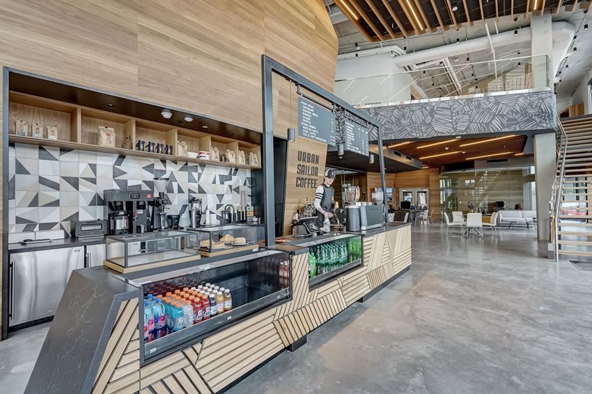 the interior of a coffee shop with a counter and a bar with drinks and food